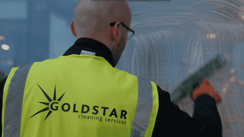 Goldstar team member cleaning window